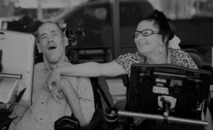 two United Ability adults in wheelchairs smiling