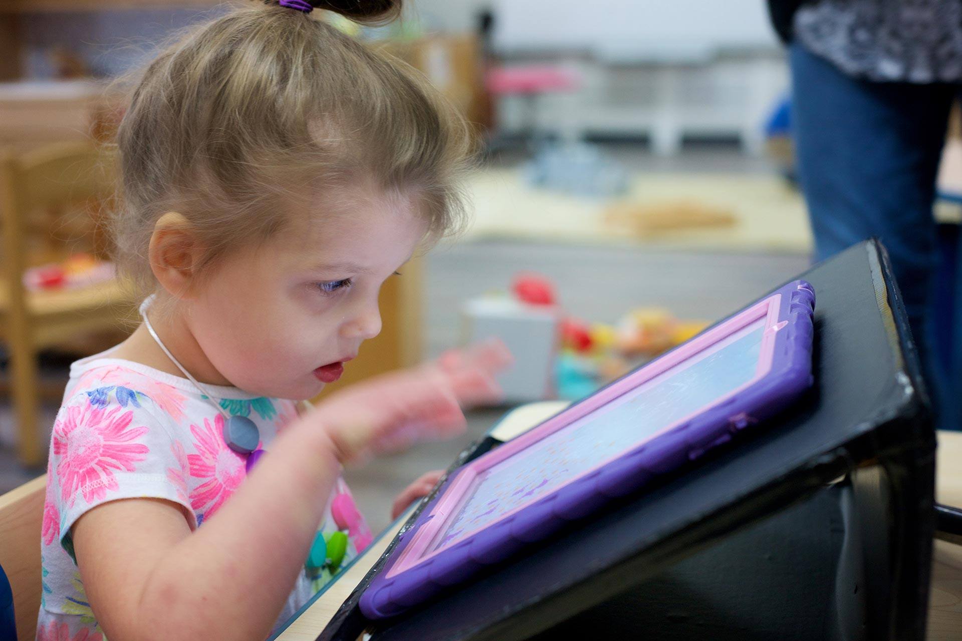 Toddler playing with ipad in classroom