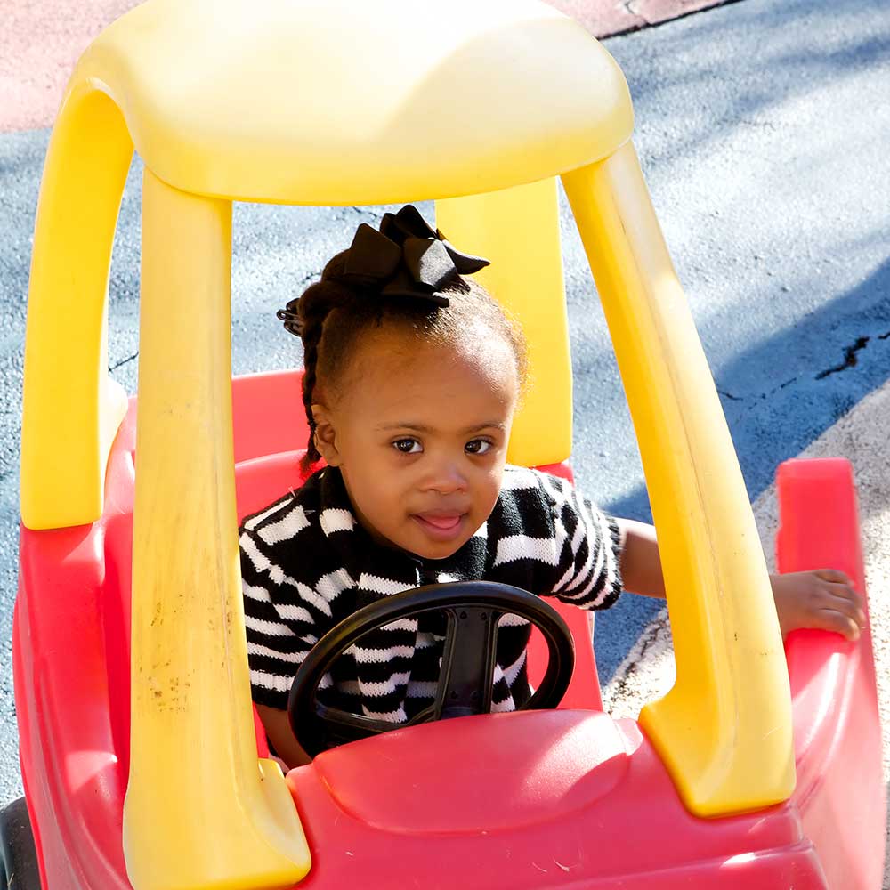 Little girl in playground car