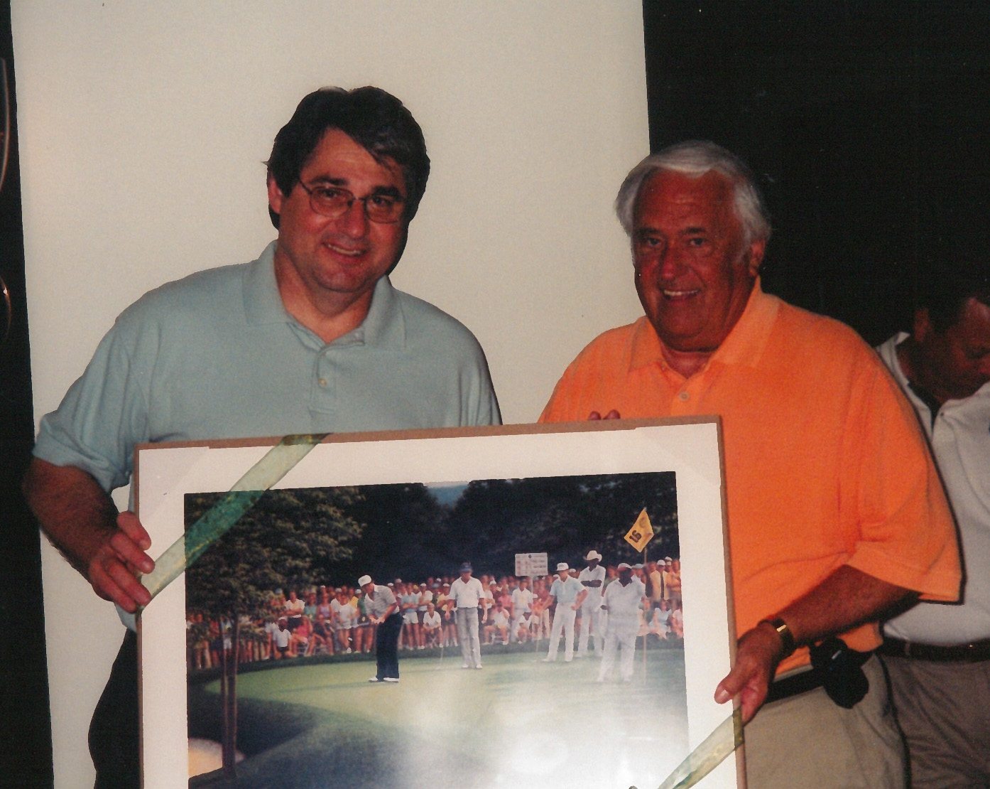 Two men smiling with framed golf picture