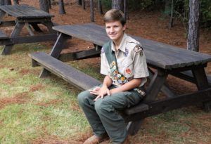 Boy scout smiling at picnic table