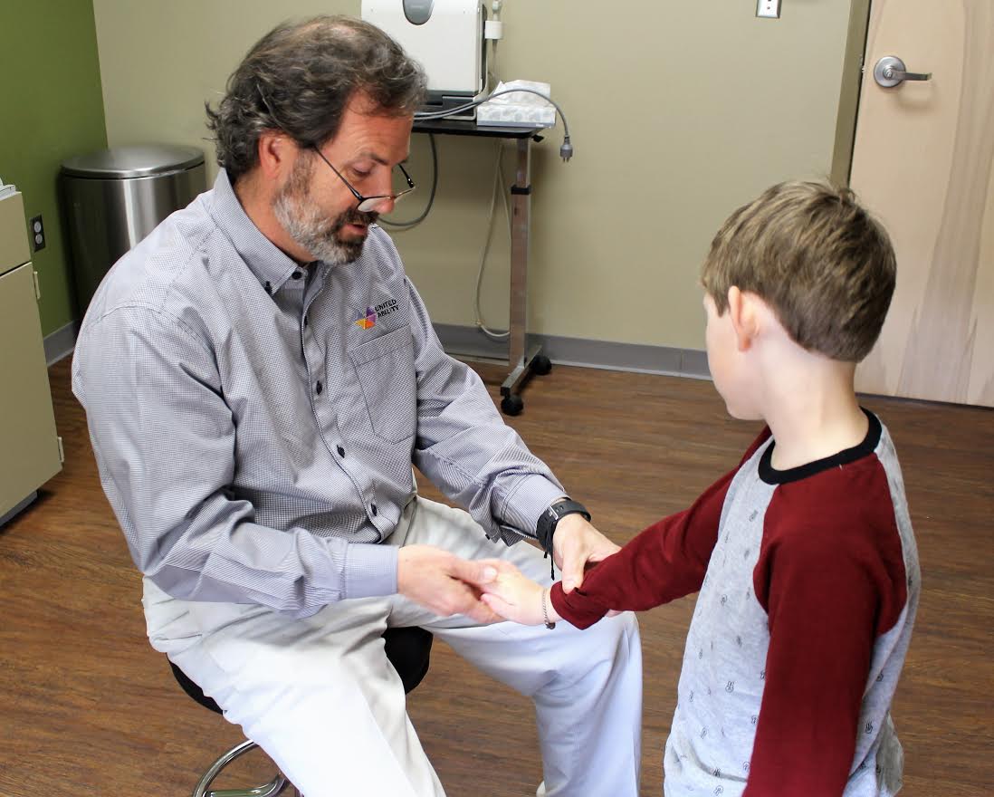 Doctor examining young boy's arm