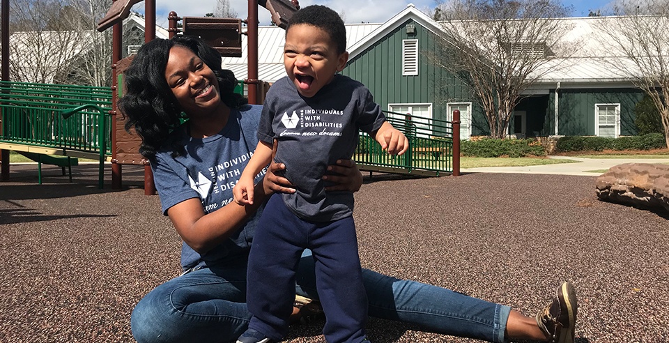 United Ability parent and child on playground wearing matching tshirts