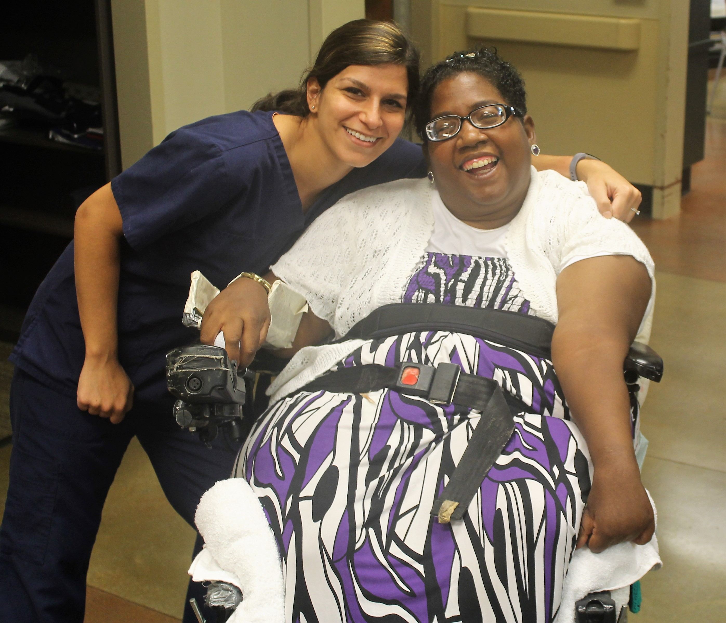 united ability employee and woman in wheel chair smiling