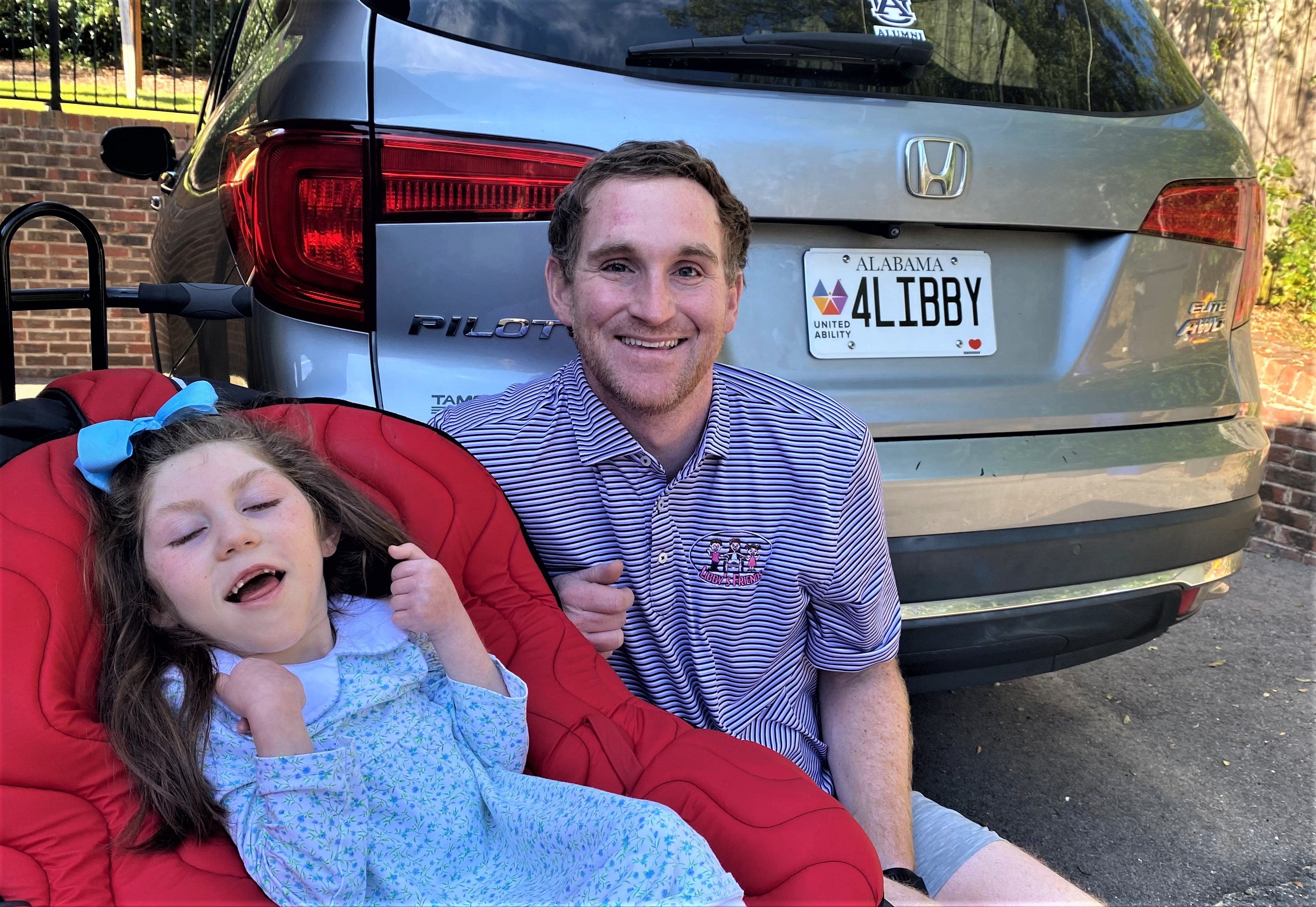 Father and daughter with United Ability License Plate